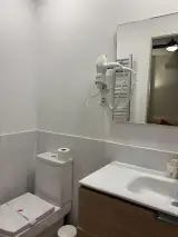 Baño del Apartamento Exterior con inodoro, lavabo, espejo, toallero y secador de pelo mural